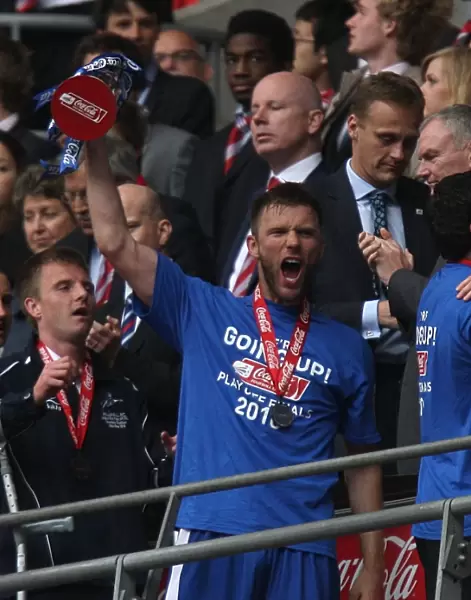 Millwall FC Celebrates Promotion to League One: Darren Ward Lifts the Play-Off Trophy at Wembley Stadium