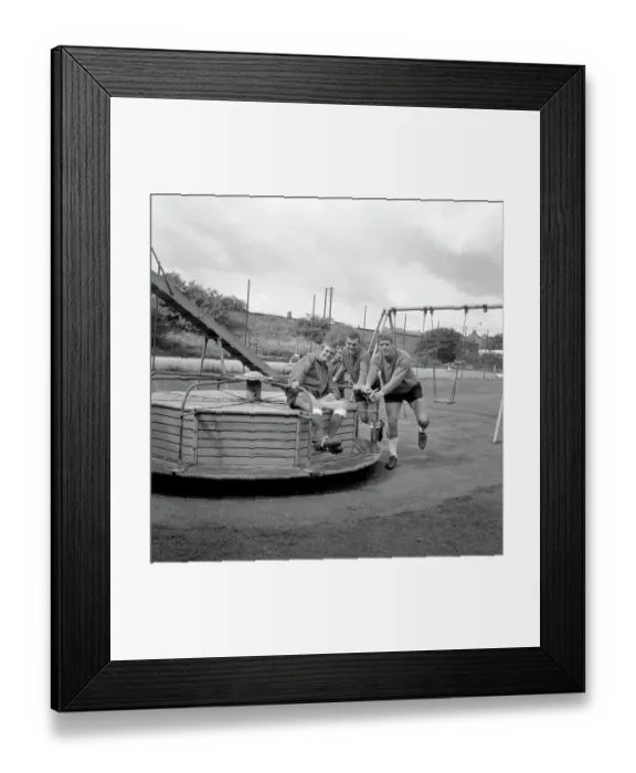 Framed Print : Millwall Football Club: Pre-Season Laughs - New Signing Derek Possee Rides a Roundabout with Team-Mates Lawrie Leslie, Keith Weller, and William Neil
